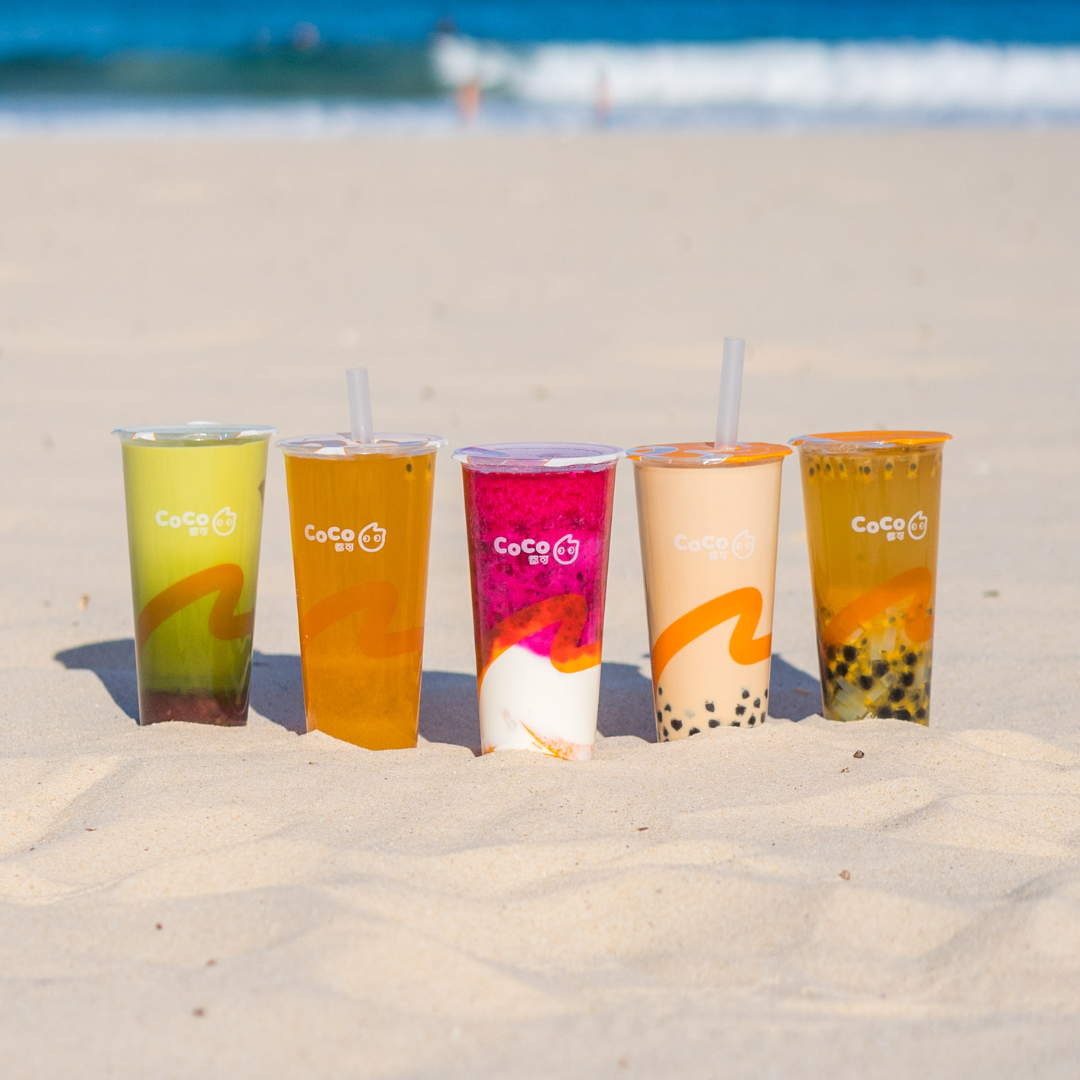 Five CoCo boba tea drinks at the beach.