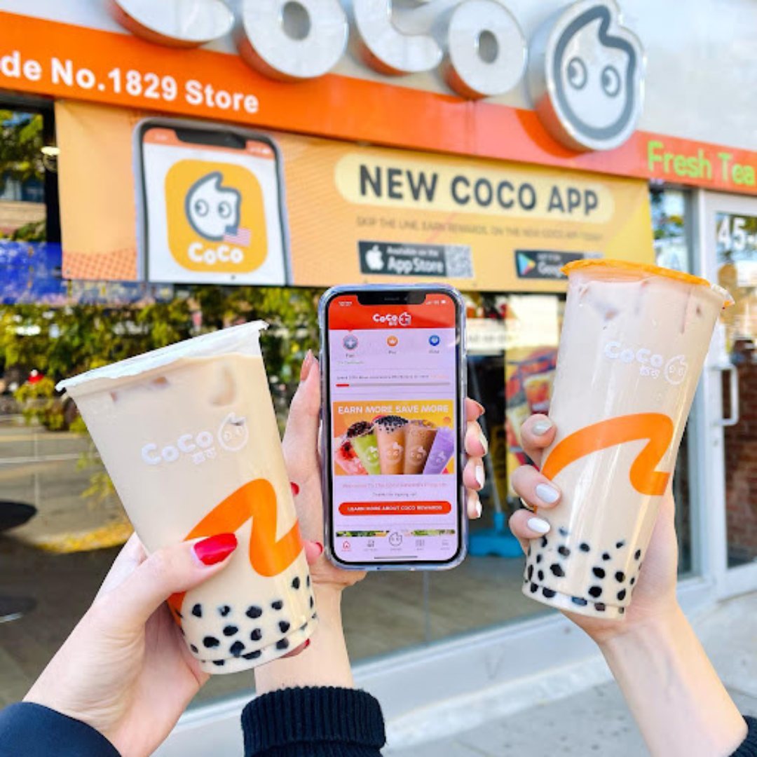 Three customers holding CoCo boba tea drinks in front of the store.