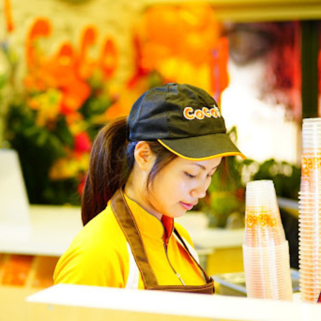 A girl in the CoCo uniform preparing boba tea drinks.