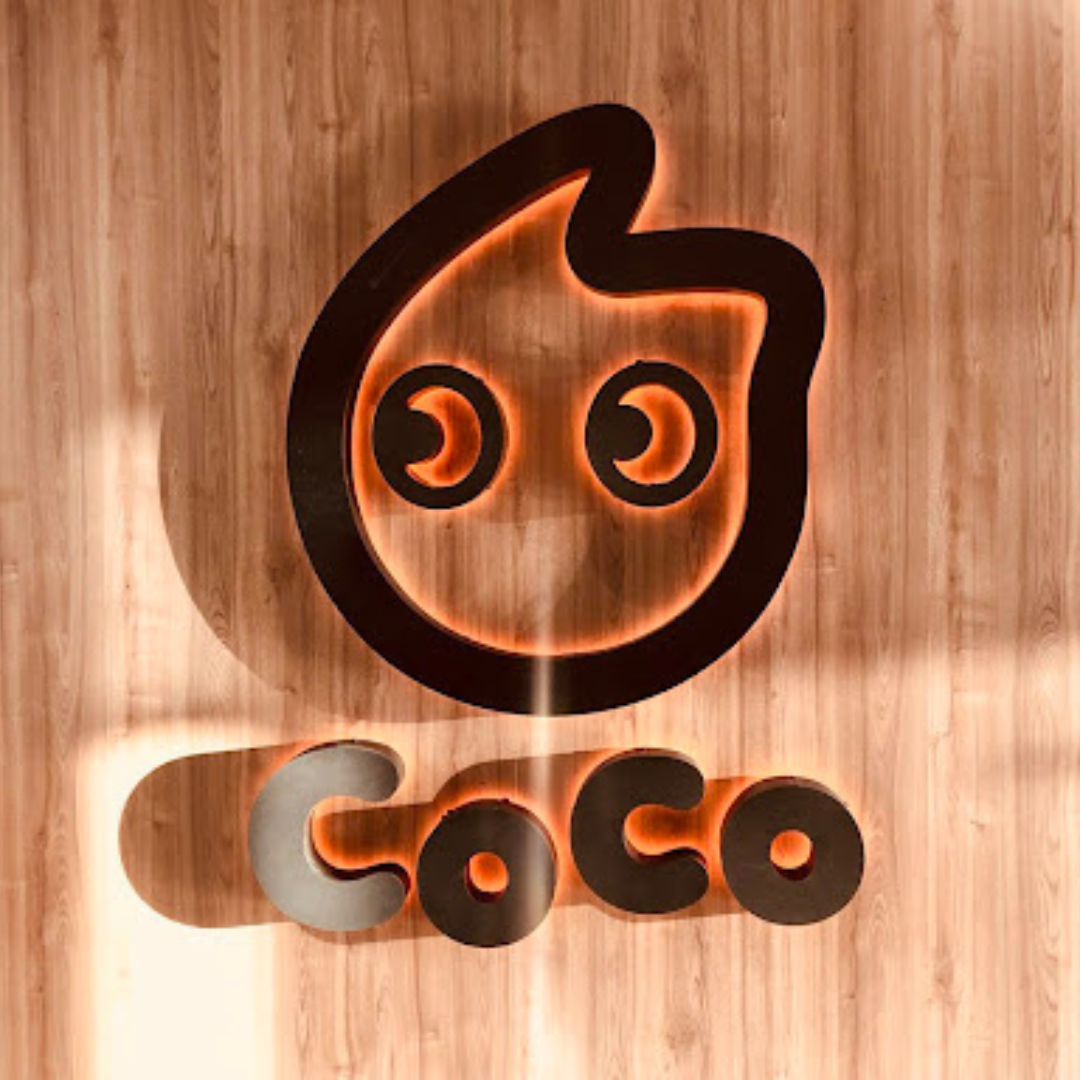 CoCo logo presented against a wooden background.