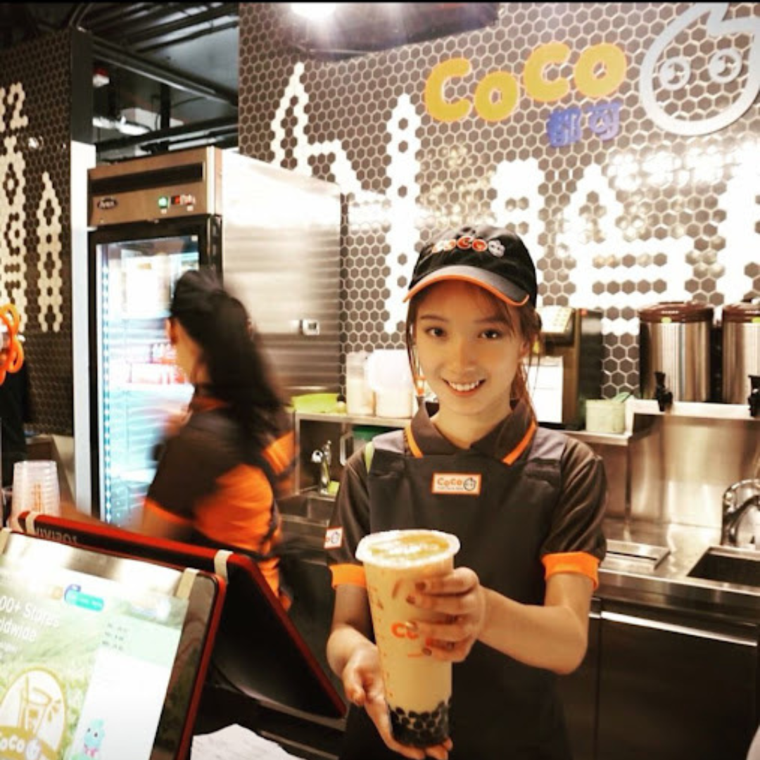 A smiling female bobarista at a US CoCo boba tea shop. 